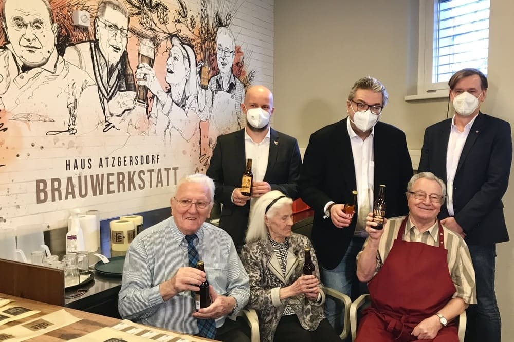 Pflegeheimbewohner brauesitzen präsentieren ihr selbstgebrautes Bier.