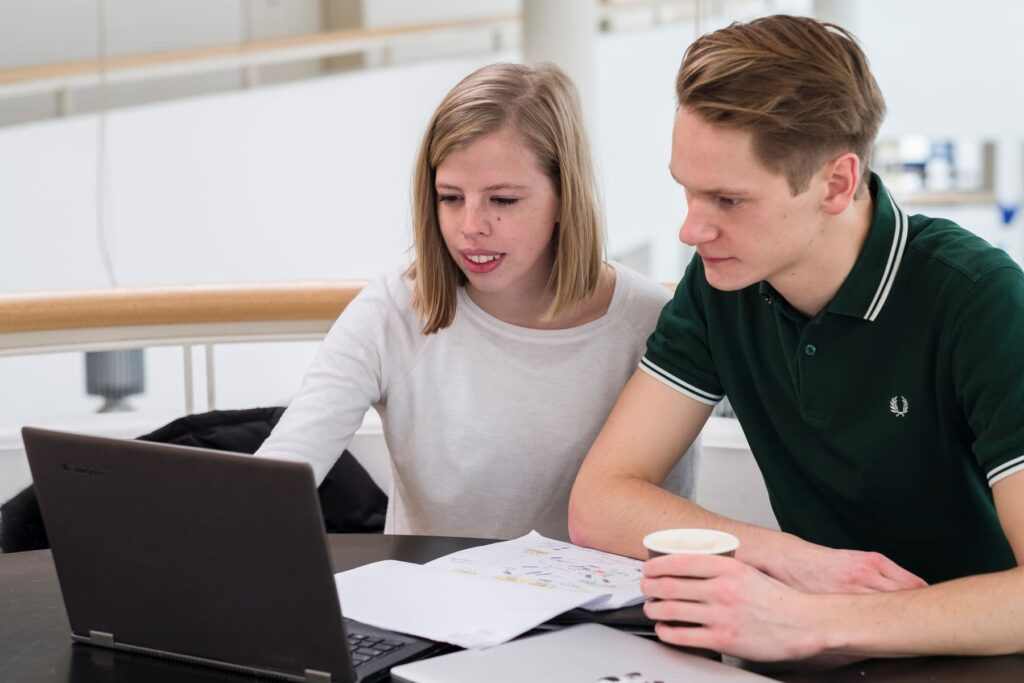 Zwei Pflegestudierende sitzen am Notebook