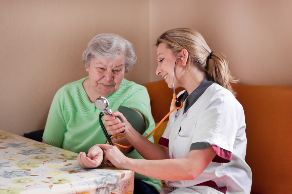 Pflegerin misst bei Seniorin den Blutdruck