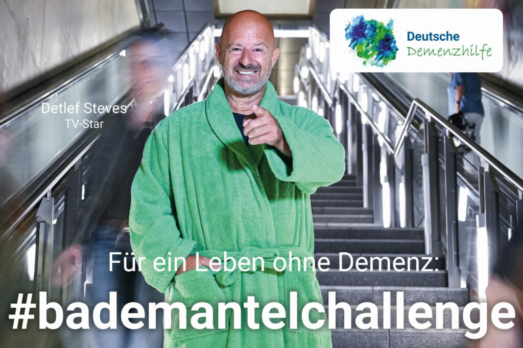 TV-Star Detlef Steves im grünen Bademantel auf einer öffentlichen Treppe im Rahmen der #bademantelchallenge