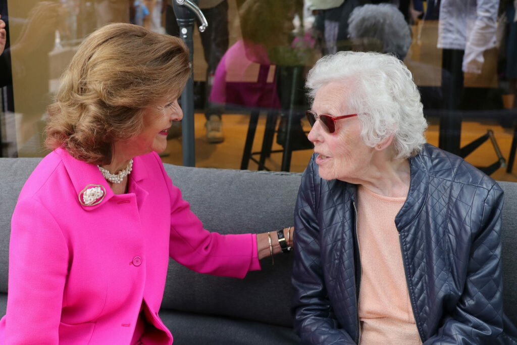 Königin Silvia von Schweden redet mit einer älteren Frau.