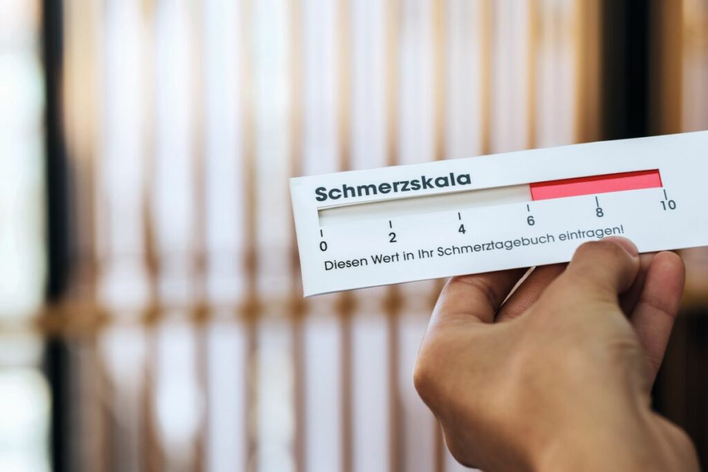 Hand hält Schmerzskala