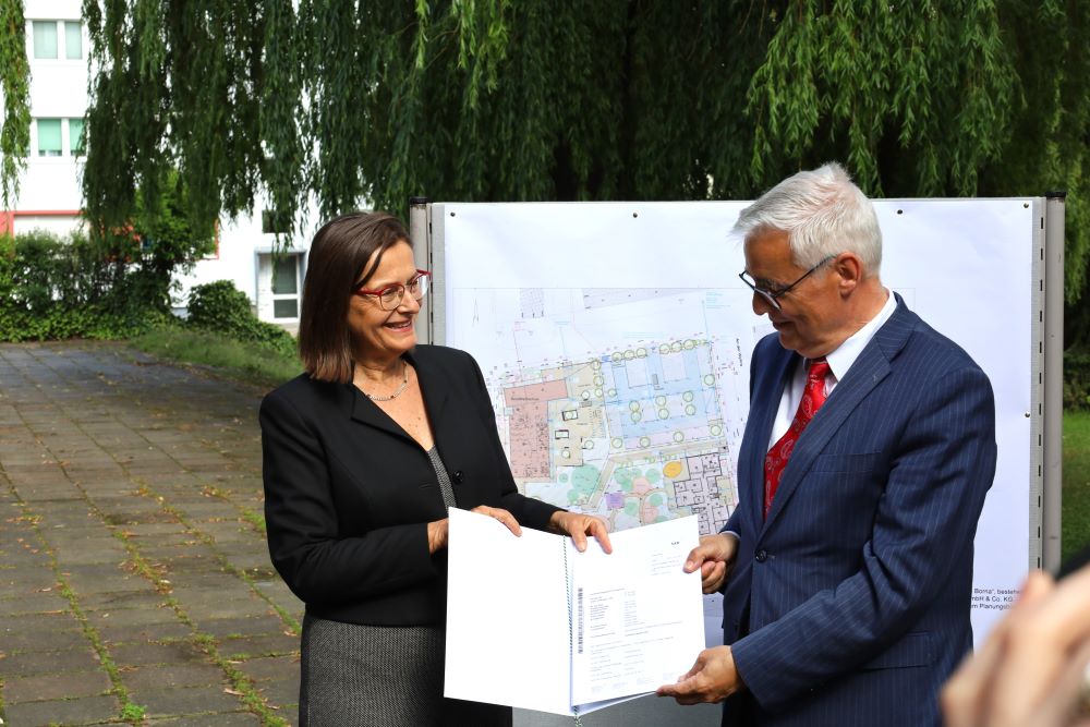 Staatssekretärin Barbara Meyer übergibt den Förderbescheid an Bornas Oberbürgermeister Oliver Urban.