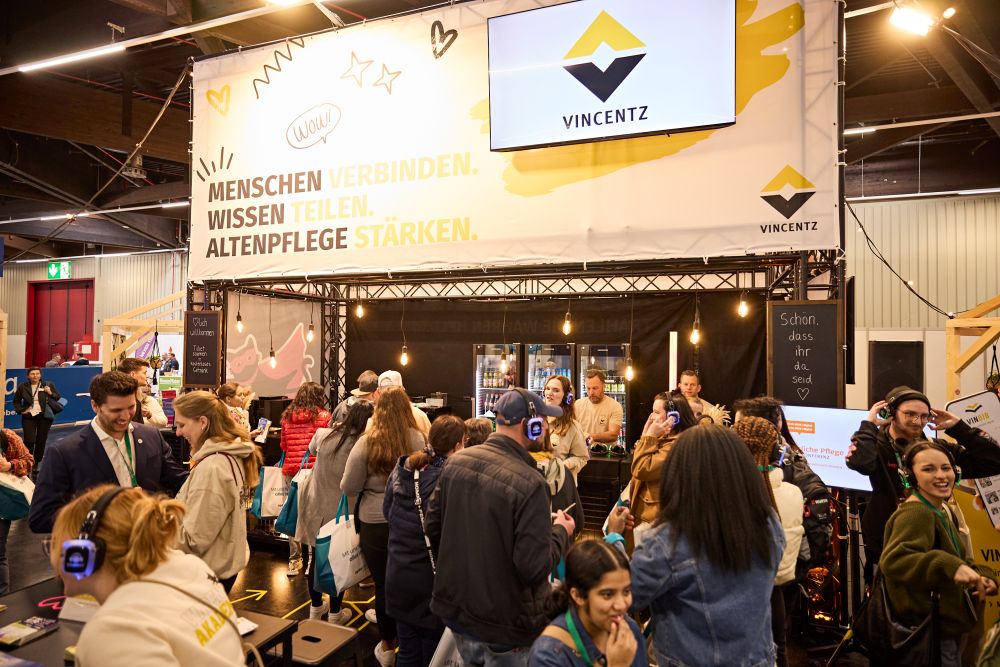Messegäste stehen vor dem Stand von Vincentz Network
