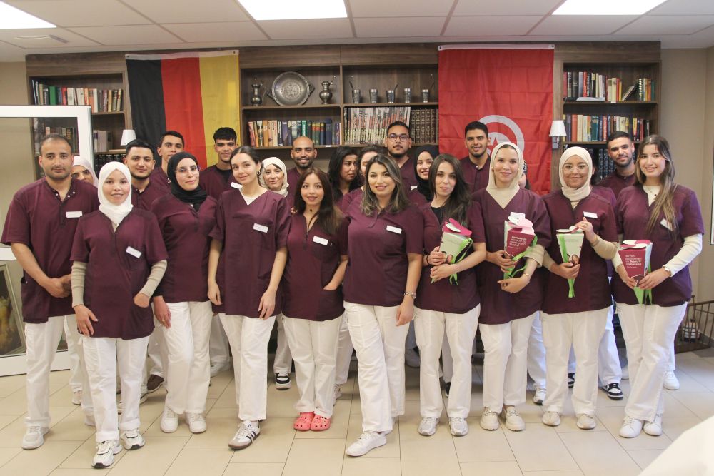 Gruppenbild von 28 tunesischen Pflege-Auszubildenden, die ihre Pflegeausbildung in der Seniorenresidenz Harburg begonnen haben. Einge halten eine kleine Zuckertüte in der Hand.