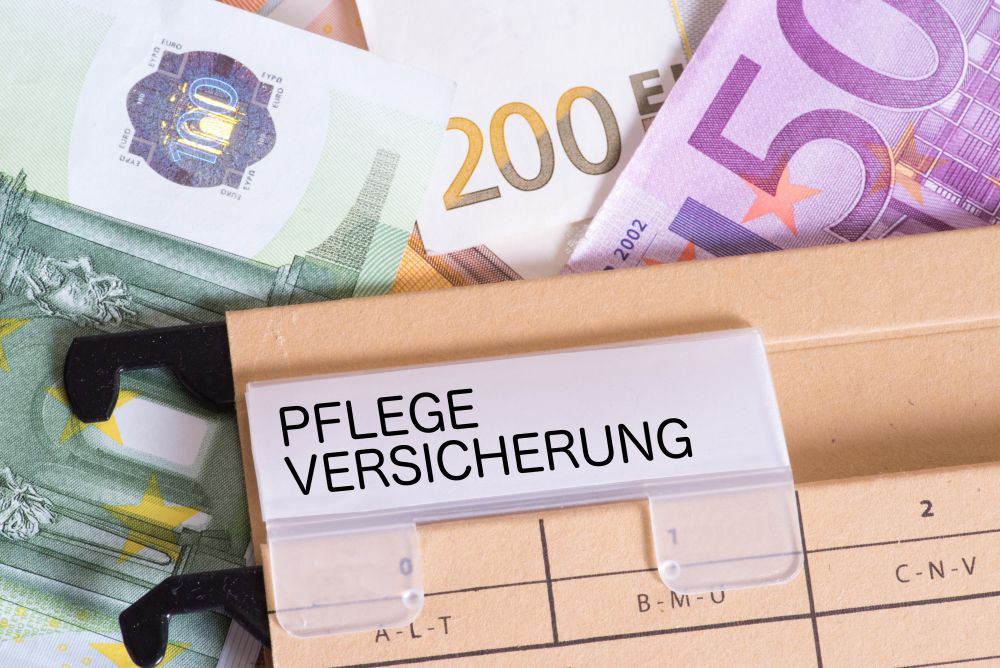 Geldscheine und ein Pflegeversicherungsschild liegen zusammen, was auf die finanziellen Herausforderungen in der Altenpflege hinweist.