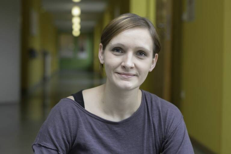 Junge Frau schaut fragend in die Kamera