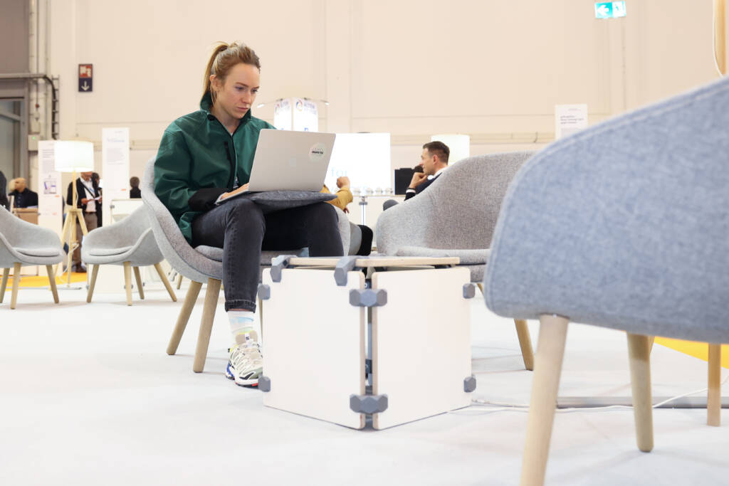 Frau am Laptop in Messehalle