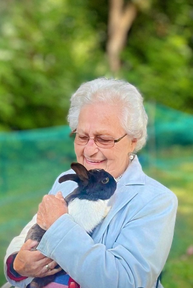 Seniorin hält Kaninchen im Arm